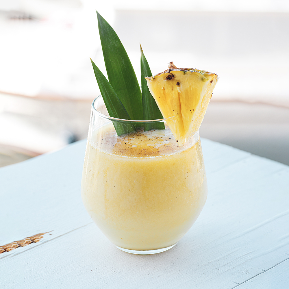 Pineapple Bliss cocktail with leaf & slice garnish